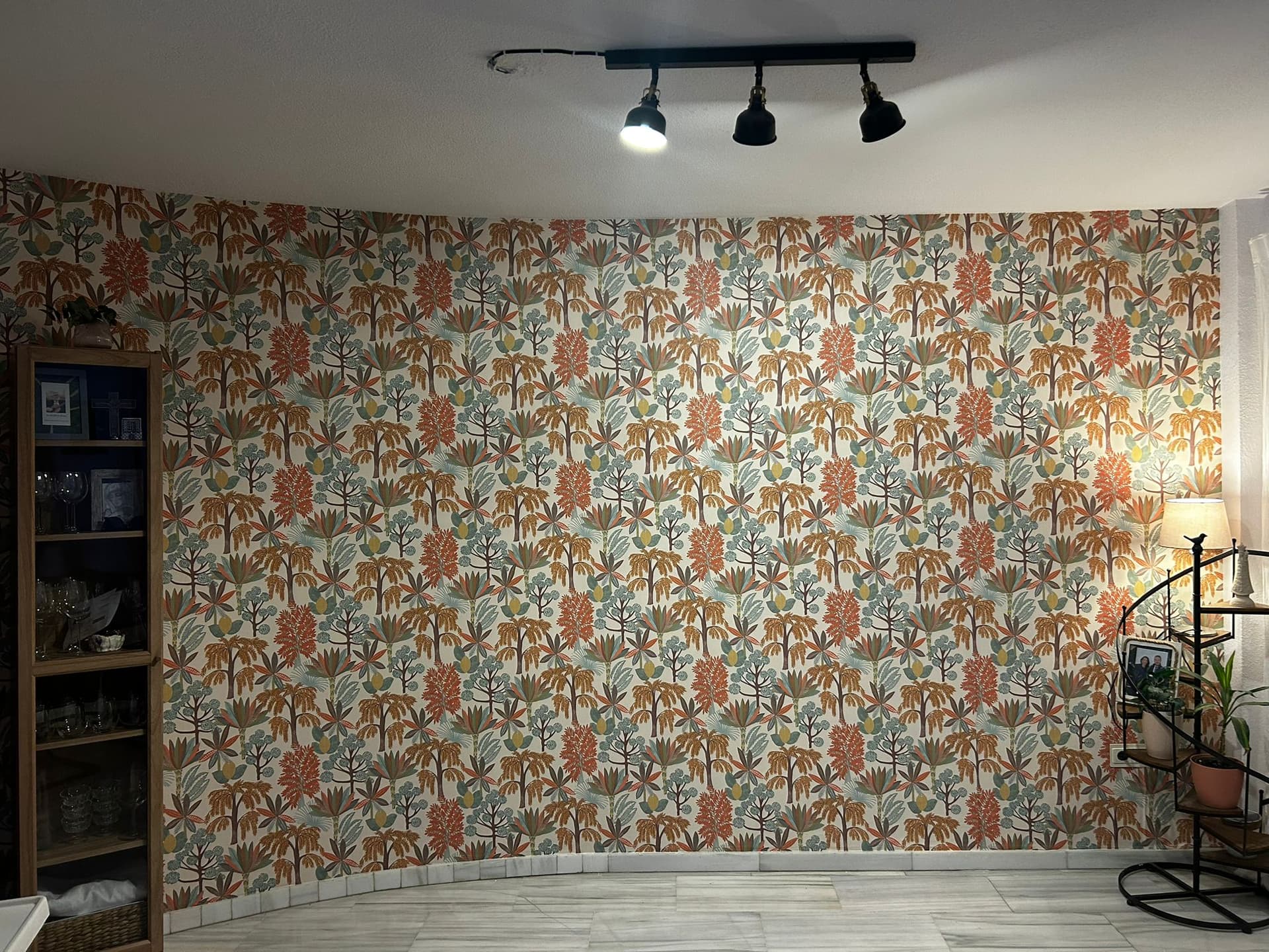 Pared curva con papel pintado de hojas tropicales