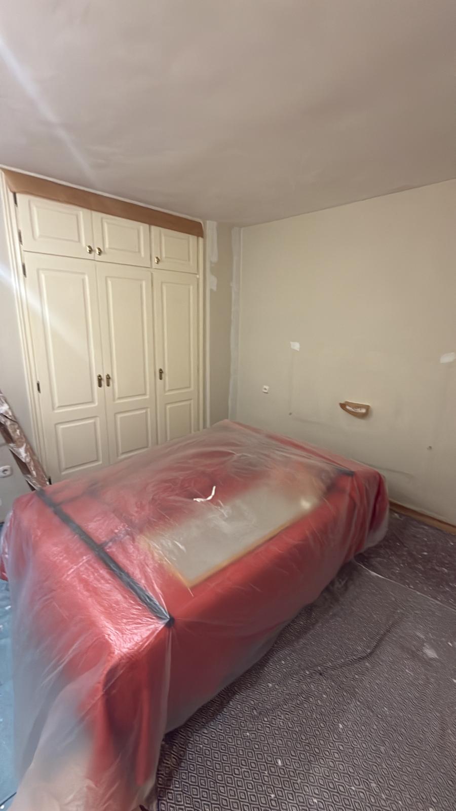 Dormitorio con los muebles protegidos, antes de pintar